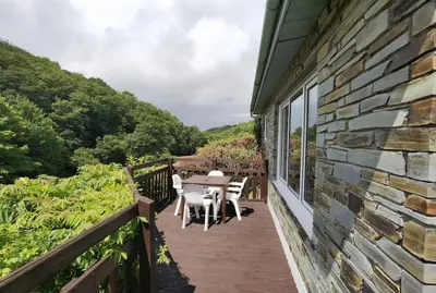 a wooden deck with a table and chairs on it at Parada Cottage at Crackington Haven, near Bude and Boscastle, Cornwall in Bude