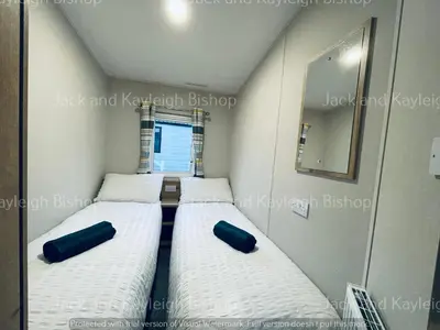 three beds in a small room with a mirror at 3-Bedroom Holiday Home with Valley Views in Newquay