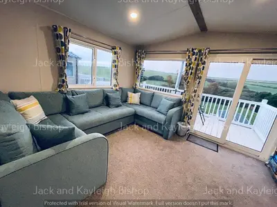a living room with a couch and a balcony at 3-Bedroom Holiday Home with Valley Views in Newquay
