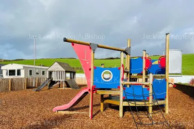 a playground with a slide and a swing at 3-Bedroom Holiday Home with Valley Views in Newquay