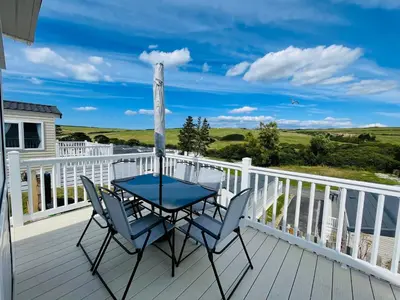 a patio with a table and chairs on a deck at 3-Bedroom Holiday Home with Valley Views in Newquay