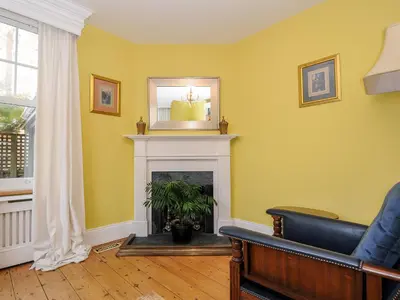 a living room with a fireplace and a mirror at Sunset House in Newquay