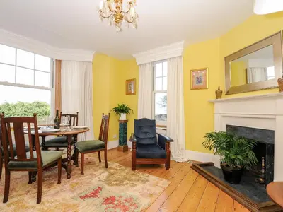 a dining room with a table and a fireplace at Sunset House in Newquay