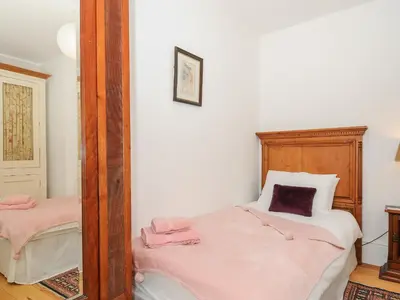 a bedroom with a mirror and a bed with pink sheets at Sunset House in Newquay
