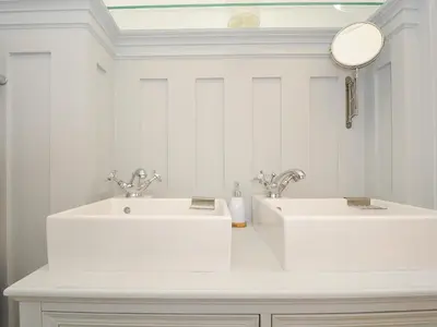 a white bathroom with two sinks and a mirror at Sunset House in Newquay