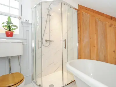 a bathroom with a shower and a bath tub at Sunset House in Newquay