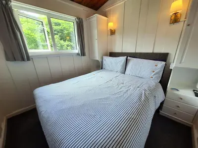 a white bed in a small room with a window at Bantry Cottage at Crackington Haven, near Bude and Boscastle, Cornwall in Bude