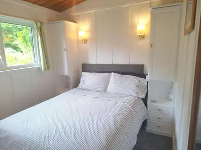 a bedroom with a white bed and a window at Kallowen Cottage at Crackington Haven, near Bude and Boscastle, Cornwall in Bude