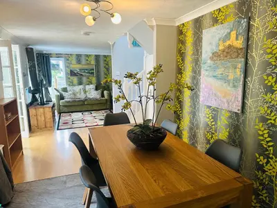 a dining room with a wooden table and chairs at Bay View Cottage in St Austell