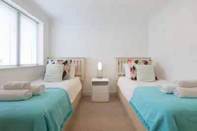 two twin beds in a room with a window at Indigo in St Ives