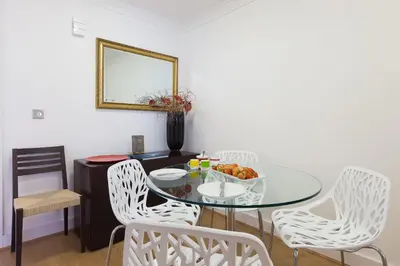 a dining room with a glass table and white chairs at Indigo in St Ives