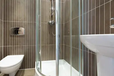 a bathroom with a shower and a toilet and a sink at Indigo in St Ives