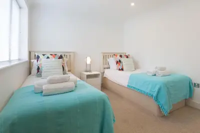 a bedroom with two beds with towels on them at Indigo in St Ives