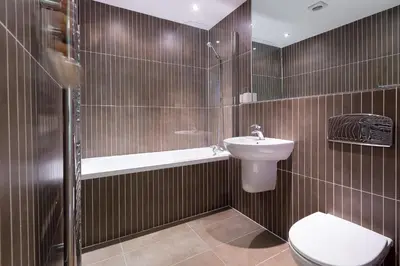 a bathroom with a toilet and a sink and a shower at Indigo in St Ives