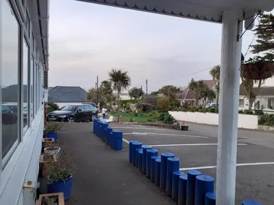 a parking lot with blue barrels in front of a building at Trevarrian Lodge in Newquay