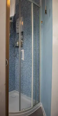 a shower with a glass door in a bathroom at Trevarrian Lodge in Newquay