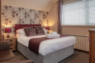 a bedroom with a large bed and a window at Trevarrian Lodge in Newquay