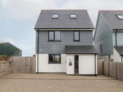 a house with white doors and a fence at Atlantic Reach in Marazion