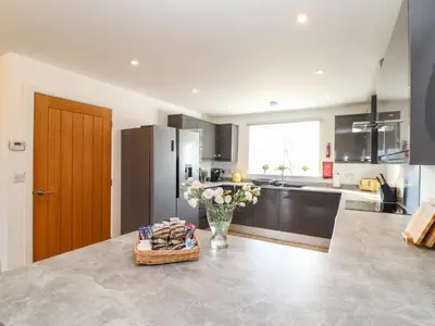 a kitchen with a vase of flowers on a counter at Atlantic Reach in Marazion