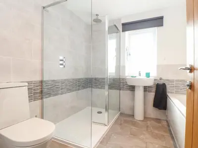 a bathroom with a shower and a toilet and a sink at Atlantic Reach in Marazion