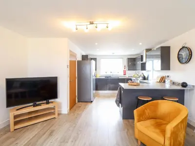 a kitchen and living room with a television and a counter at Atlantic Reach in Marazion