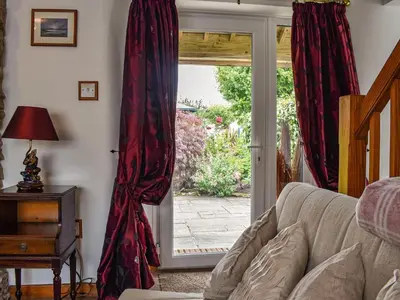 a living room with a sliding glass door at Tinners Gate in Saint Cleer