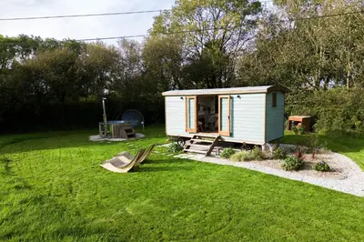 a tiny house in a yard with a swing at Fern in Bude
