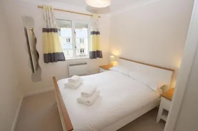 a bedroom with a white bed with two towels on it at Stunning Holiday home with amazing surroundings! in Budock Water