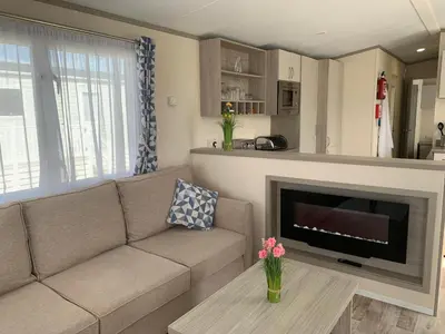 a living room with a couch and a fireplace at Beautiful Cornish Getaway, Static Caravan - Newperran Holiday Resort in Cubert