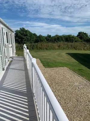 a white fence on a porch of a house at Beautiful Cornish Getaway, Static Caravan - Newperran Holiday Resort in Cubert