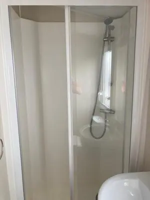 a glass shower in a bathroom with a toilet at Beautiful Cornish Getaway, Static Caravan - Newperran Holiday Resort in Cubert