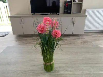 a vase filled with pink flowers in a room at Beautiful Cornish Getaway, Static Caravan - Newperran Holiday Resort in Cubert