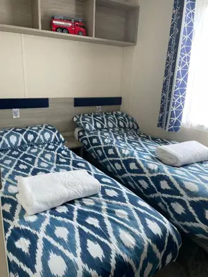 a room with two beds with blue and white blankets at Beautiful Cornish Getaway, Static Caravan - Newperran Holiday Resort in Cubert