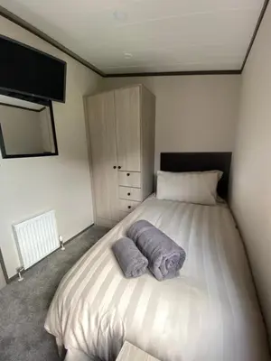 a bedroom with a bed with two pillows on it at Riverwood Lodge in Porth