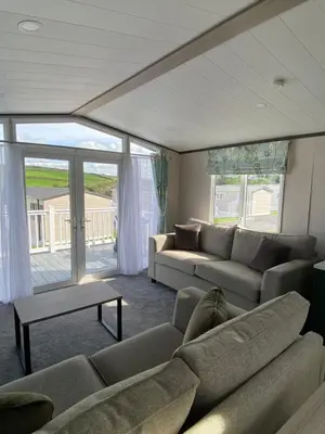 a living room with a couch and a table at Riverwood Lodge in Porth