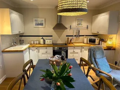 a kitchen with a table with a blue table cloth and a table sidx sidx sidx at Cargibbitt Annexe in Liskeard