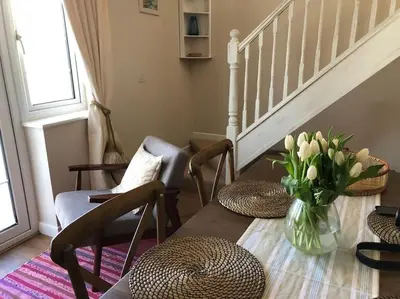 a living room with a vase of flowers on a table at Cargibbitt Annexe in Liskeard