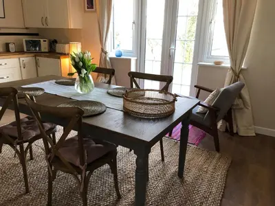 a dining room table with chairs and a vase of flowers at Cargibbitt Annexe in Liskeard
