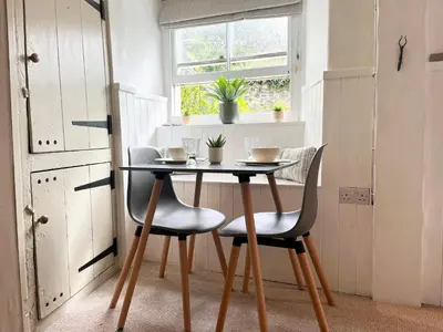 a table and chairs in a room with a window at Cosy Cottage Central Marazion with Parking in Marazion