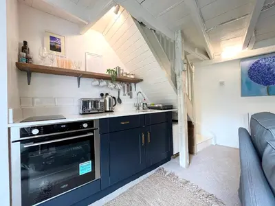 a kitchen with black cabinets and a stove at Cosy Cottage Central Marazion with Parking in Marazion