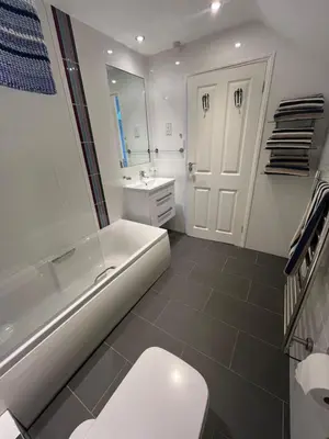 a white bathroom with a toilet and a sink at Elysian Fields B&B in Helston