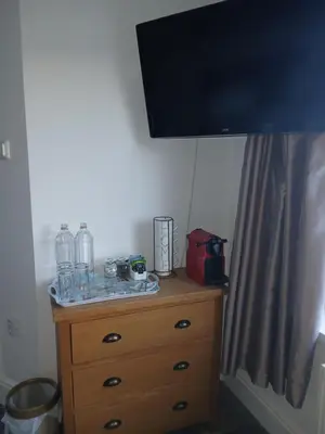 a wooden dresser with a television on top of it at Elysian Fields B&B in Helston