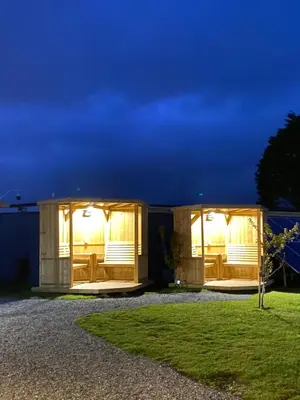 a modular house with lights in a yard at night at Elysian Fields B&B in Helston