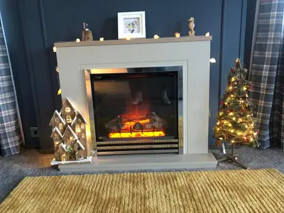 a living room with a fireplace with a christmas tree at Mawgan Stays Mawgan Porth in Mawgan Porth