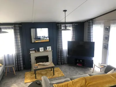 a living room with a couch and a tv at Mawgan Stays Mawgan Porth in Mawgan Porth