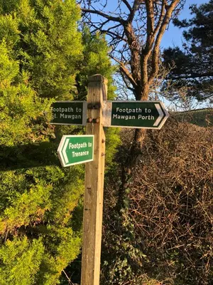 a wooden pole with street signs on it at Mawgan Stays Mawgan Porth in Mawgan Porth