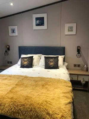 a bedroom with a large bed with a yellow blanket at Mawgan Stays Mawgan Porth in Mawgan Porth