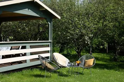 two chairs and a table in the grass next to a fence at Safari Cornwall in Bodmin