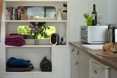 a kitchen with white shelves and a microwave at Safari Cornwall in Bodmin