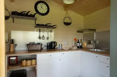a kitchen with a clock on the wall at Safari Cornwall in Bodmin
